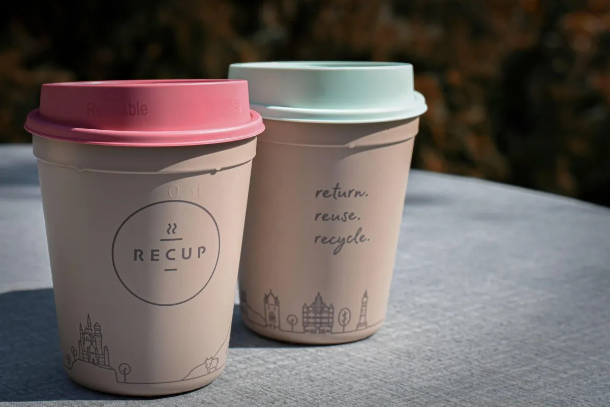 Reusable branded coffee cup on an office desk