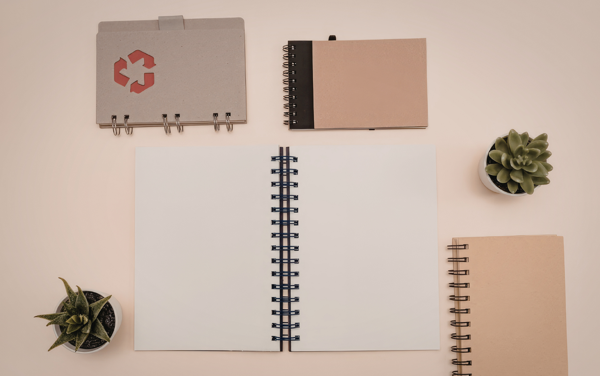 Zero-waste office supplies on a tidy desk with recycled folders and a bamboo organiser.
